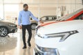 young africanamerican man came to see automobiles in dealership or cars showroom Royalty Free Stock Photo