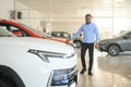 young africanamerican man came to see automobiles in dealership or cars showroom