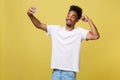 Young afro american black man smiling happy taking selfie self portrait picture with mobile phone looking excited having