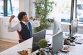 Young afro-american business man stretches contentedly in his office after receiving a good news