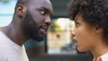 Young afro-american couple arguing outdoor, misunderstanding, jealous spouse
