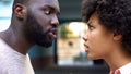 Young afro-american couple arguing outdoor, misunderstanding, jealous spouse