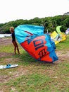 Young afro american girl prepares the kite surf kite in a tropical environment. Water sports in the