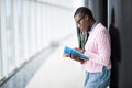 Young beauty afro american girl student in glasses holding notebooks and studying prepare for exam in modern University hall Royalty Free Stock Photo