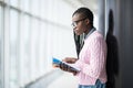 Young beauty afro american girl student in glasses holding notebooks and studying prepare for exam in modern University hall Royalty Free Stock Photo