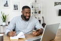 Young Afro American guy working online making notes Royalty Free Stock Photo