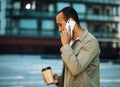 Young afro american man dressed casual holding a cup of coffee to go, smiling happy using smartphone at the city. Royalty Free Stock Photo