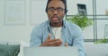 Young afro american man in glasses and headphones holding video call consultation with mentor, studying remotely at home Royalty Free Stock Photo