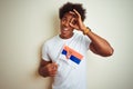 Young afro american man holding Serbia Serbian flag standing over isolated white background with happy face smiling doing ok sign Royalty Free Stock Photo