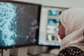 Young Afro-American modern Muslim businesswoman wearing a scarf in a creative bright office workplace with a big screen. Royalty Free Stock Photo