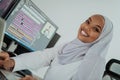 Young Afro-American modern Muslim businesswoman wearing a scarf in a creative bright office workplace with a big screen. Royalty Free Stock Photo