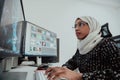 Young Afro-American modern Muslim businesswoman wearing a scarf in a creative bright office workplace with a big screen. Royalty Free Stock Photo