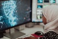 Young Afro-American modern Muslim businesswoman wearing a scarf in a creative bright office workplace with a big screen. Royalty Free Stock Photo