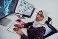 Young Afro-American modern Muslim businesswoman wearing a scarf in a creative bright office workplace with a big screen. Royalty Free Stock Photo