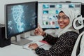 Young Afro-American modern Muslim businesswoman wearing a scarf in a creative bright office workplace with a big screen. Royalty Free Stock Photo