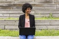 young afro American woman using laptop. Green backgrounds. Casual clothing. Lifestyles. Business.Millennial.