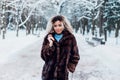 Afro american girl wearing in fur coat ank walking in winter park Royalty Free Stock Photo