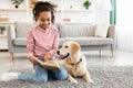 Young afro girl reading book with dog at home Royalty Free Stock Photo