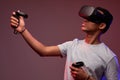 young afro guy play VR games in virtual reality helmets on bright colourful background