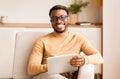 Young Afro Man Holding Tablet Computer Sitting On Couch Indoor Royalty Free Stock Photo