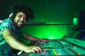 Young Afro man working in music recording studio - Male audio engineer mixing a sound