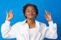 Young afro woman relax with closed eyes against blue background Royalty Free Stock Photo