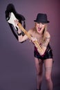 Young aggressive woman with tattoo smashing guitar Royalty Free Stock Photo