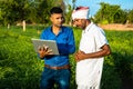 young agronomist researcher discussing with farmer at field,