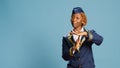 Young air hostess showing timeout symbol in studio,