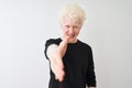 Young albino blond man wearing black t-shirt standing over isolated white background smiling friendly offering handshake as Royalty Free Stock Photo