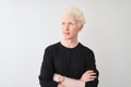 Young albino blond man wearing black t-shirt standing over isolated white background smiling looking to the side and staring away Royalty Free Stock Photo