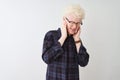 Young albino blond man wearing casual shirt and glasses over isolated white background covering ears with fingers with annoyed Royalty Free Stock Photo