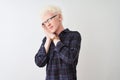 Young albino blond man wearing casual shirt and glasses over isolated white background sleeping tired dreaming and posing with