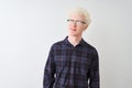 Young albino blond man wearing casual shirt and glasses over isolated white background smiling looking to the side and staring Royalty Free Stock Photo