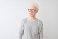 Young albino blond man wearing striped t-shirt and glasses over isolated white background smiling looking to the side and staring Royalty Free Stock Photo