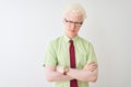 Young albino businessman wearing shirt and tie standing over isolated white background skeptic and nervous, disapproving