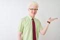 Young albino businessman wearing shirt and tie standing over isolated white background smiling cheerful presenting and pointing Royalty Free Stock Photo