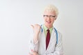 Young albino doctor man wearing stethoscope standing over isolated white background smiling with happy face looking and pointing Royalty Free Stock Photo