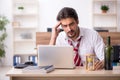 Young alcohol addicted male employee in time management concept