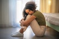 Young alone African American girl with afro hair-style sitting on floor hugging her legs. Depression, loneliness and Royalty Free Stock Photo