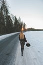 Young and alone girl dressed fur coat and dress standing around outdoor road. Sunset on the background. Sunlight and faded colors