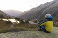 Young alpinist enjoys the warming sunbeams after a strict mountain tour