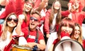 Young amateur football supporter fans cheering with flags watching local soccer cup match at stadium - Friends people group with Royalty Free Stock Photo