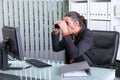 Amazed business man looking with binoculars at the screen Royalty Free Stock Photo