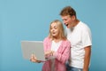 Young amazed couple friends guy girl in white pink empty blank design t-shirts posing isolated on pastel blue background Royalty Free Stock Photo