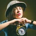 Young amazed woman in pith helmet holding alarm clock Royalty Free Stock Photo