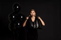 Young woman with shopping bags looking up standing isolated over black background Royalty Free Stock Photo