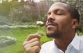 Young american african businessman in informal clothes meditating taking a deep breath with flower.Business yoga and