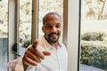 Young american african confident businessman in white shirt pointing hand to camera and smiling inside corporate office Royalty Free Stock Photo