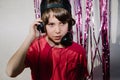 Young American boy wearing headphones near the purple confetti tapes - the concept of DJing